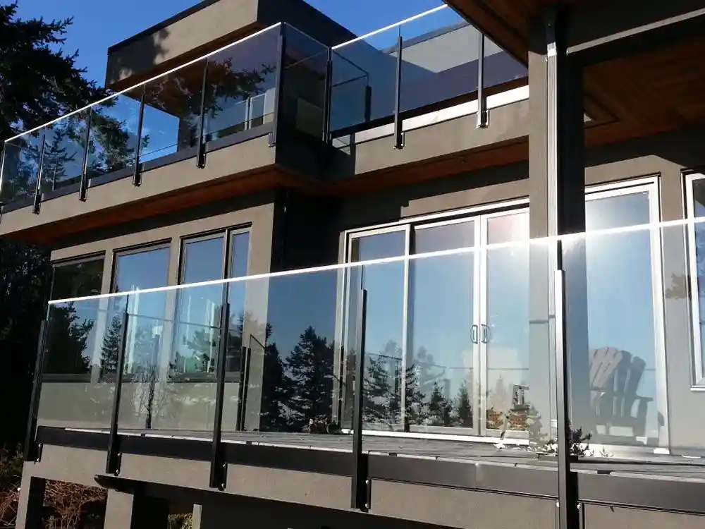 Modern house exterior featuring large glass windows and LDH Aluminum Ltd. – Railings & Gates